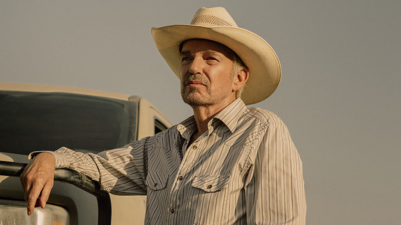 Tommy leans against a truck in 