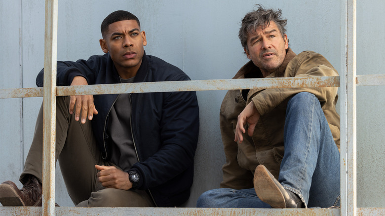 John Stewart and Hal Jordan sit on a walkway behind a railing in "Lanterns" (2026)