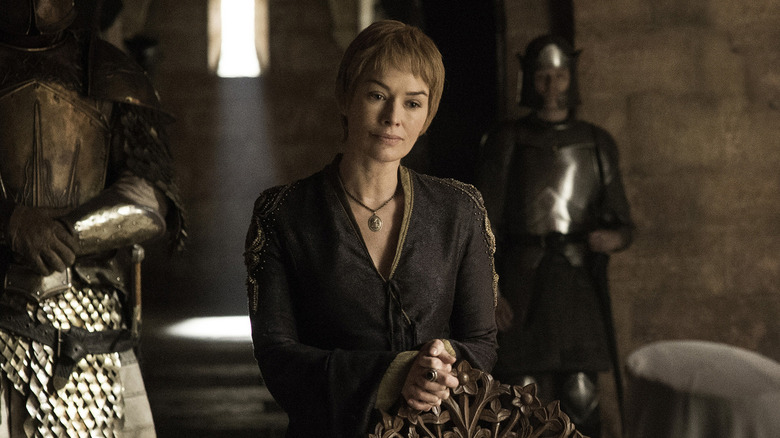 Cersei standing behind chair