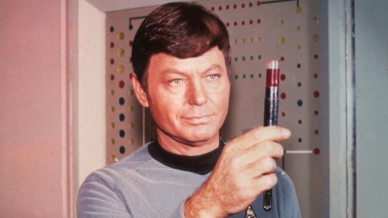 Dr. Leonard "Bones" McCoy holding a vial in "Star Trek: The Original Series" (1966)