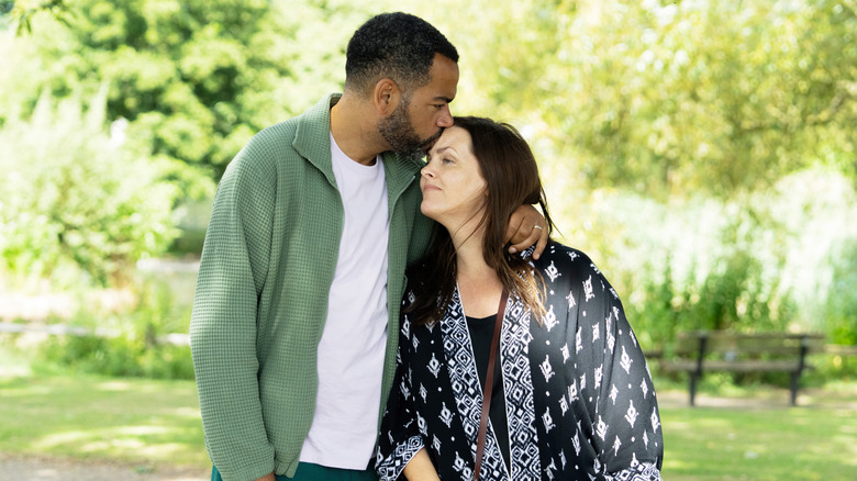 Nick kissing Liz on the forehead as they stand outside