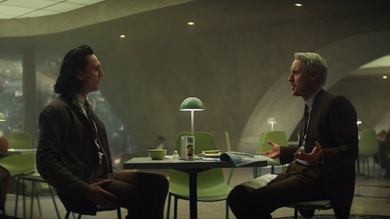 Loki and Agent Mobius talking at a table