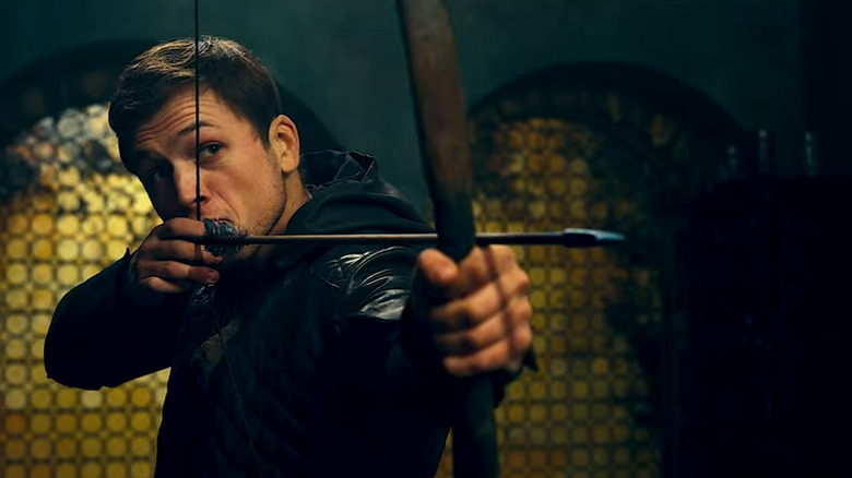 Taron Edgerton firing an arrow