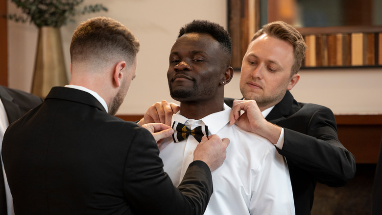 Kwame Appiah getting bow tie fitted