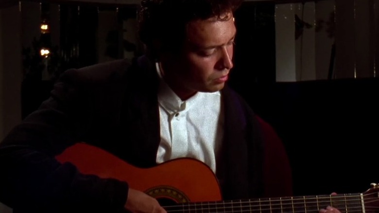 El Mariachi strums an acoustic guitar in "El Mariachi" (1993)