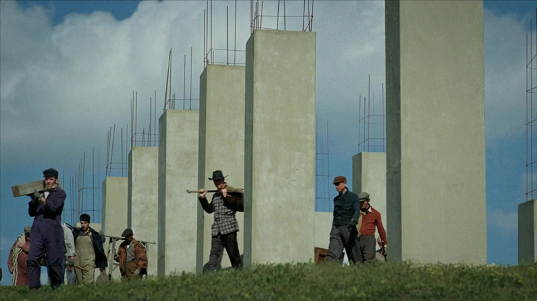 Workers construct pillars of the church in "The Brutalist" (2024)