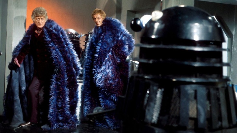 The 3rd Doctor and a companion facing off against a Dalek in "Doctor Who"