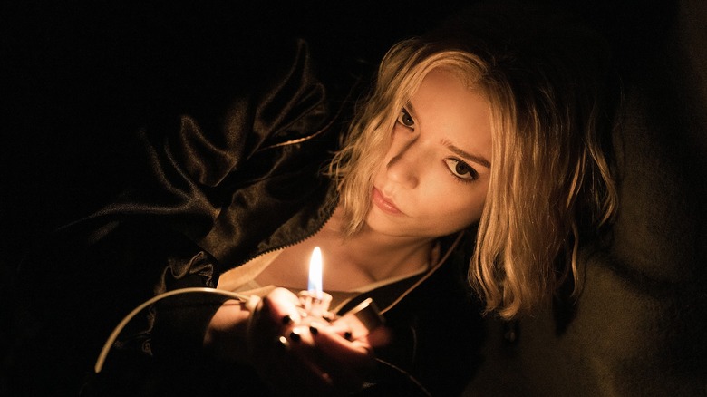 Lucky holding a lit lighter in a dark, cramped space