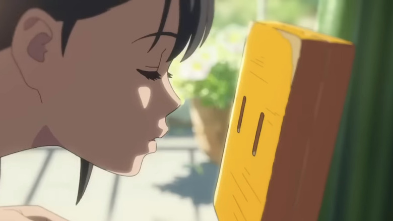 Suzume leans in to kiss a chair