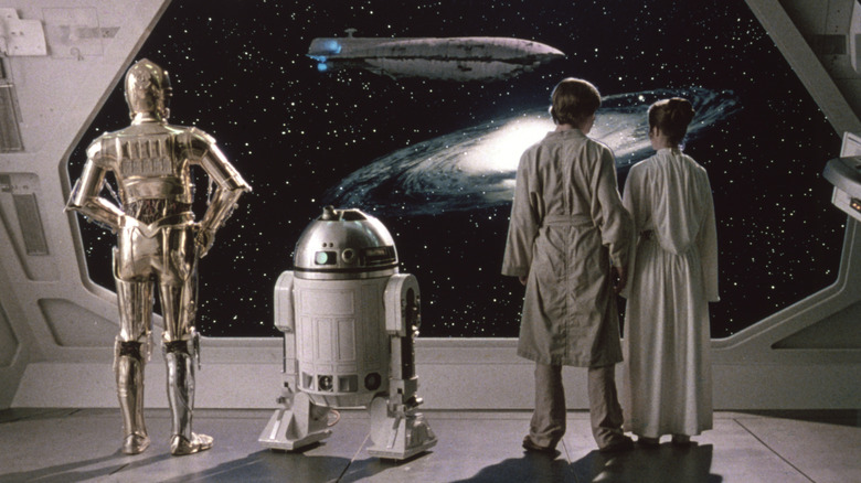 C3PO R2D2 Luke and Leila looking out of a window into space in Star Wars: A New Hope
