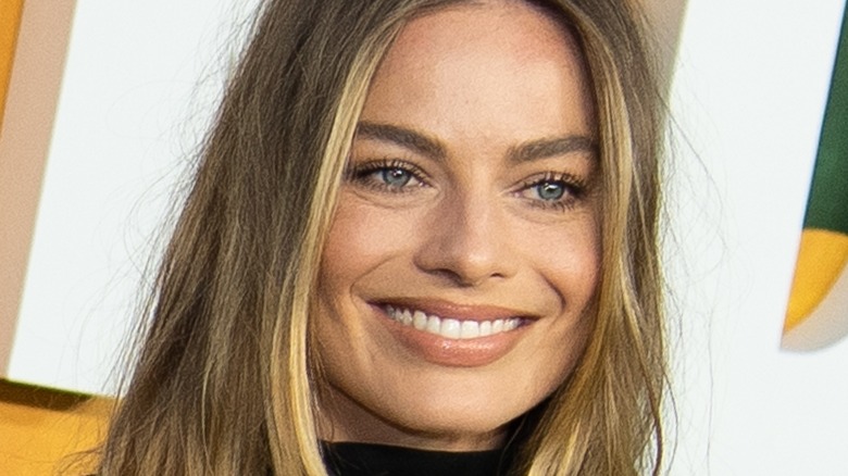 Margot Robbie smiling at a premiere