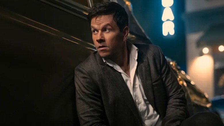 Parker hides behind a car in 