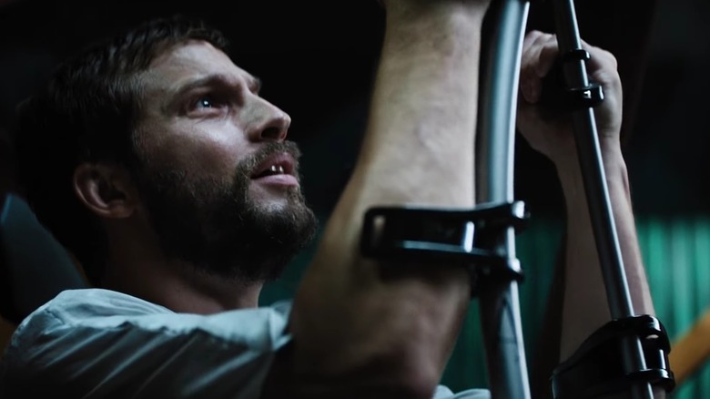 Grey holds up the crutches attached to his forearms