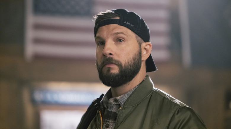 Pete Calvin staring before an American flag in 