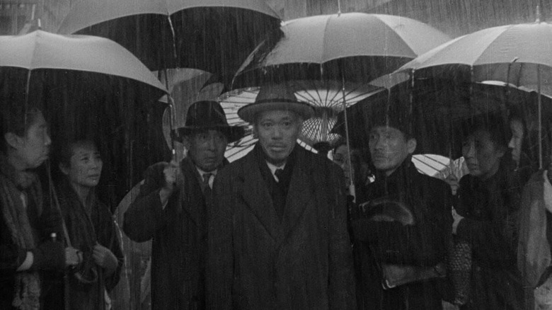 Kanji Watanabe standing amidst a crowd in the rain in "Ikiru" (1952)