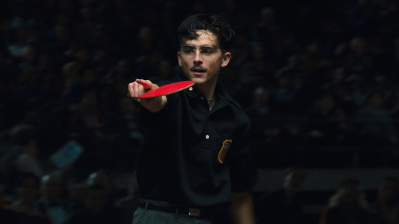 Timothée Chalamet as Marty Mauser pointing during game