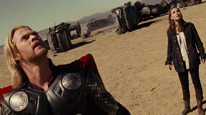 Thor and Jane looking up toward the sky in "Thor" (2011)