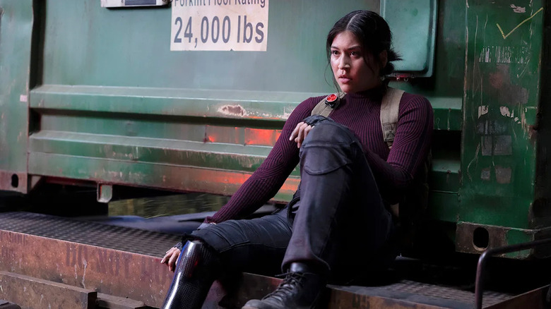 Echo sits against a metal structure with a bended knee in Echo.
