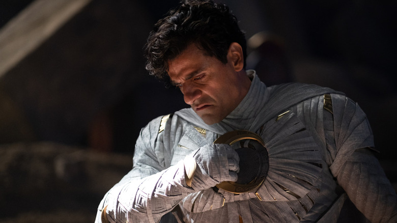 Marc Spector stands unmasked in the Moon Knight suit with a disgusted look in Moon Knight.
