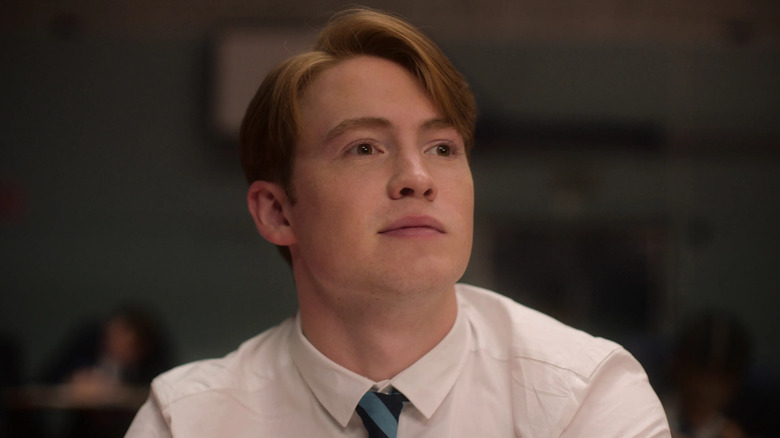 Nick wearing a tie looking up in Heartstopper