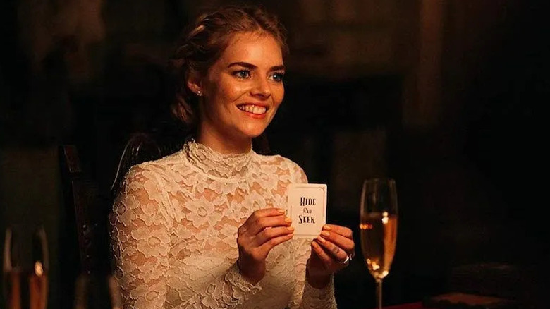 Grace holding the hide and seek card in her wedding gown in Ready or Not