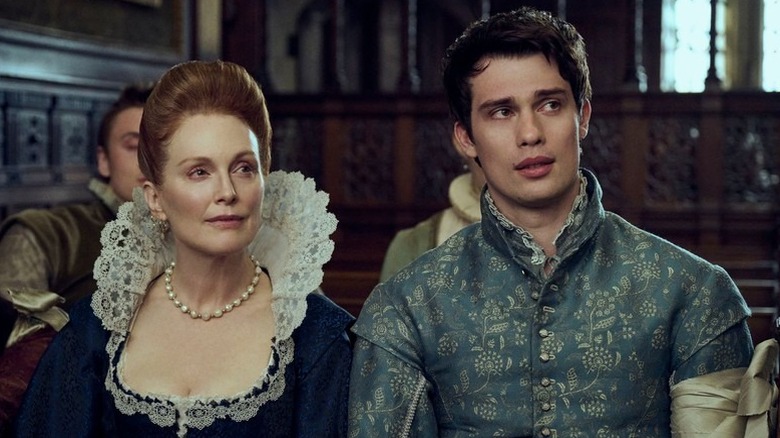 Mary and George sit in the royal court and listen to the king in "Mary & George" (2024)