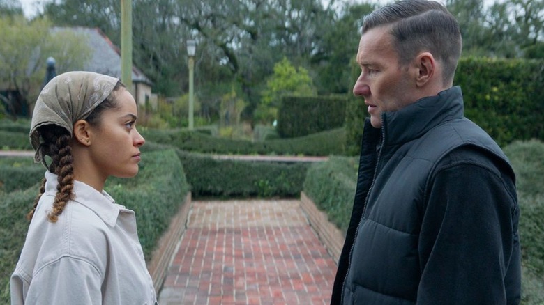 Maya and Narvel standing face-to-face in a garden
