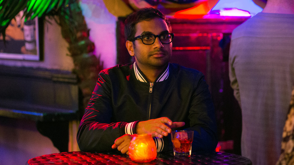 Aziz Ansari sitting at table