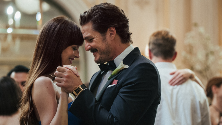 Lucy and Harry dance alongside couples at a wedding in 