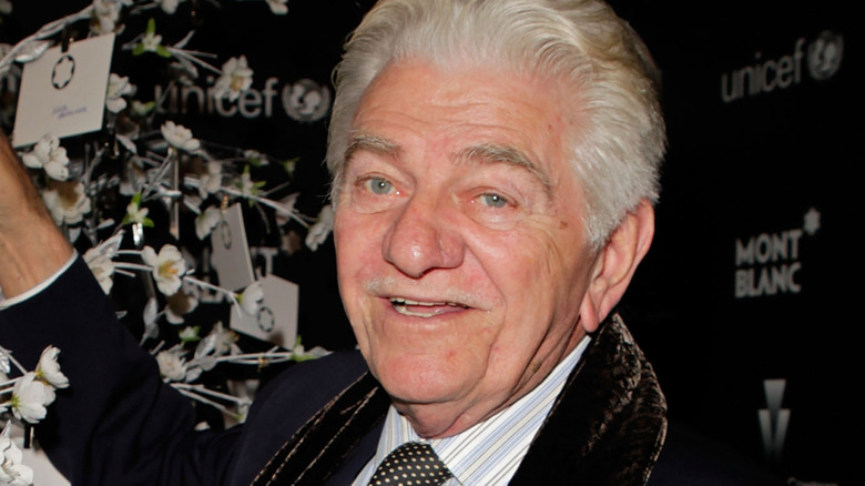 Seymour Cassel holds flower in hand