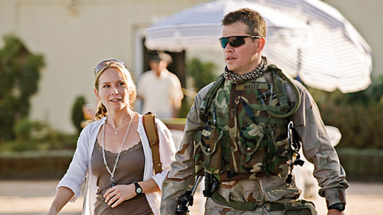 Roy Miller in uniform and sunglasses walks with reporter Lawrie Dayne in "Green Zone" (2010)