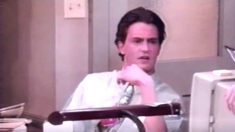 Matt Bailey sitting at a desk in "Home Free" (1993)