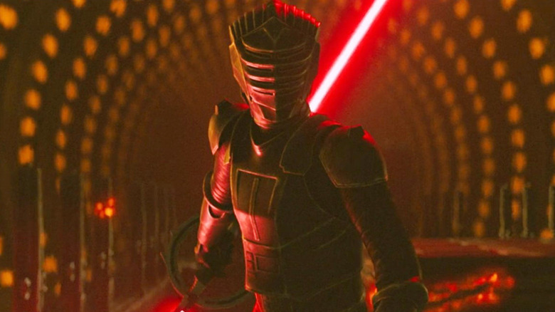 Marrok stands on a train with his lightsaber behind his back, facing Maul and Devon in 
