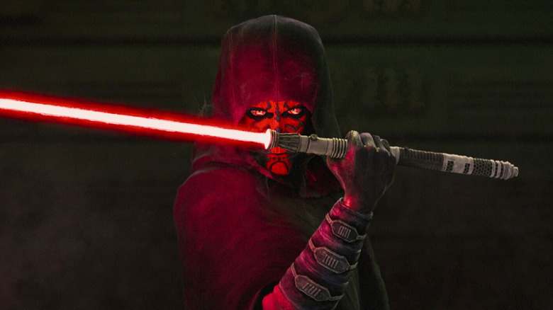 Maul igniting his red lightsaber across his hooded face in Star Wars: Maul — Shadow Lord (2026)