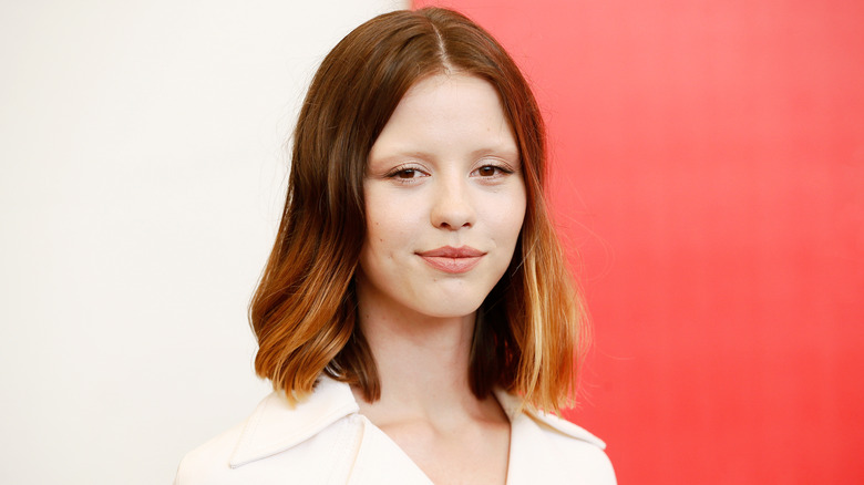 Mia Goth smirks