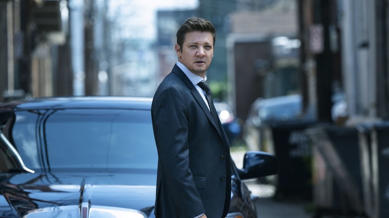 McLusky stands in front of a car