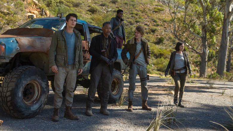 The main characters of The Maze Runner: The Death Cure stand outside of a large patchwork truck (2028)