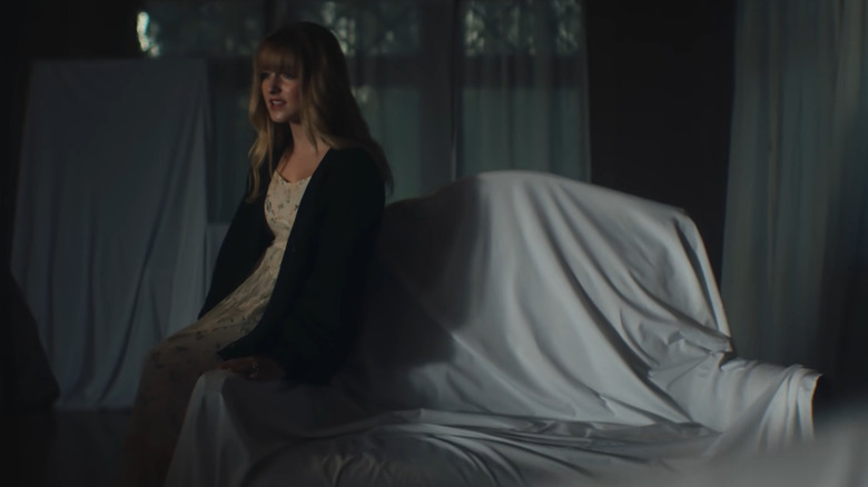 Mckenna Grace singing, sitting on a covered couch