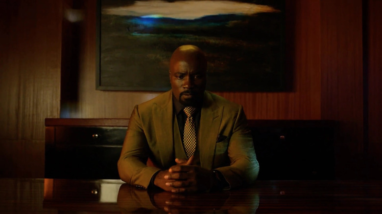 Luke Cage sits calmly at his desk in Luke Cage