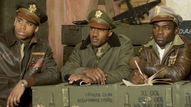 Three Black army pilots leaning on a crate in "Red Tails"