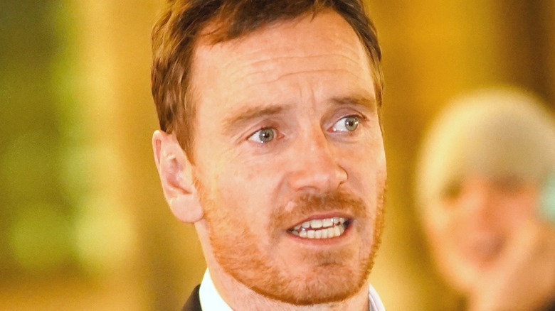 Michael Fassbender in front of gold background