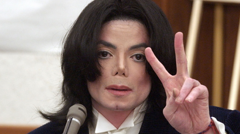 Michael Jackson flashes the peace sign in court in 2002