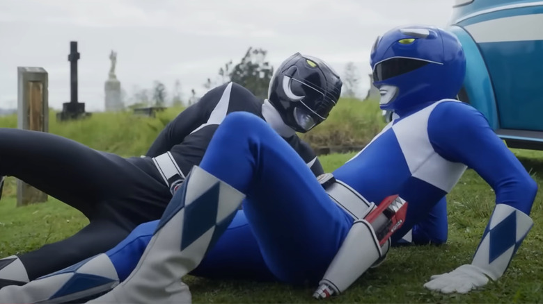 Black and Blue Power Rangers laying on grass