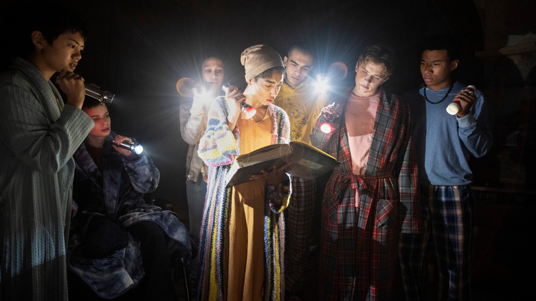 The Midnight Club look at book with flashlights