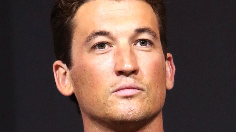 Miles Teller listens at event