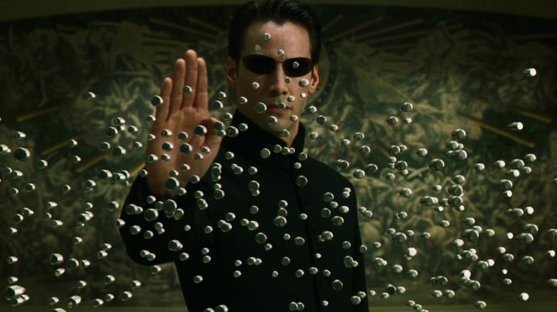 Neo using his mastery of the simulation to freeze a hail of bullets
