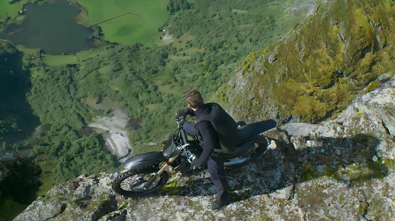Ethan Hunt sitting on a motorcycle looking out over a cliff