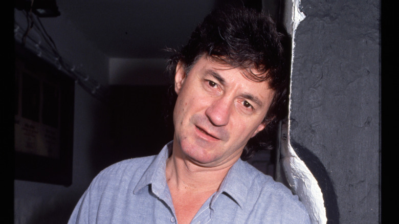 Ion Caramitru leans against a wall