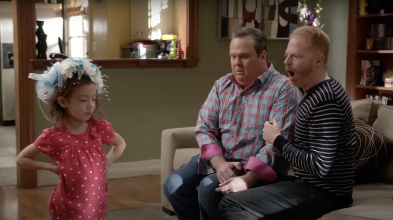 Lily, Cameron and Mitchell in Modern Family, sitting in living room