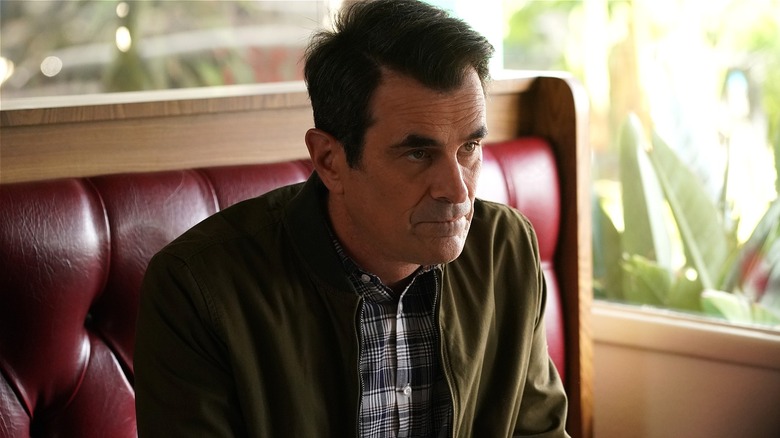 Phil Dunphy looking sad sitting in a restaurant (2020)